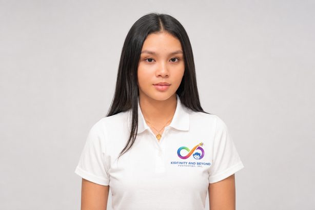 Portrait of Athalia Suarez in a white Kidfinity and Beyond polo shirt against a light grey background.