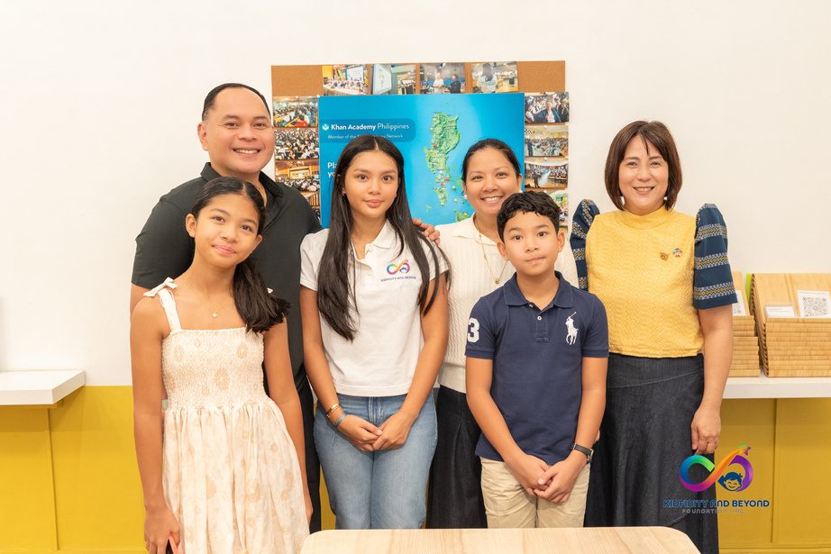Athalia Suarez and her family stand with Mrs. Wilma Huang in front of a museum display.